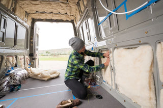 Woman adding insulation to a van
